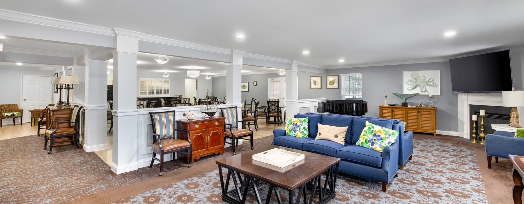 Resident lounge at The Gardens of Annapolis senior living apartments in Maryland, featuring carpeted flooring and chairs.