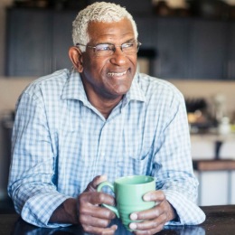 a man with a coffee mug smiling