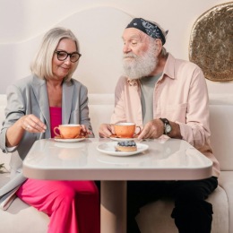 a couple sitting at a table with mugs