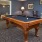 a room with a pool table and chairs